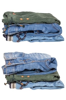 Stack of jeans clothes. Collage set of two stacks of jeans for kids isolated on a white background. Denim fashion for children. Macro.