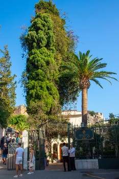 Taormina, Sicily, Italy - 28 September 2023. The street Via Teatro Greco with ancient theatre of Taormina left and the Grand Hotel Timeo right. City views, facades, architecture.