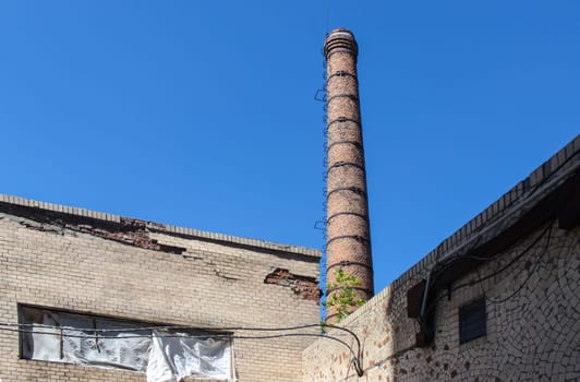 old tall brick chimney on blue sky background