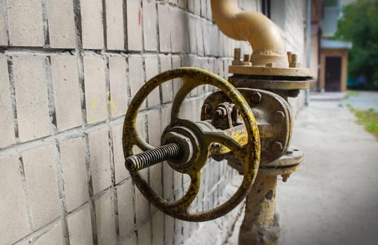 background of an old gas faucet on the background of the remnants of the tile and the bitumen surface