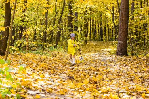 Girl with a dog jack russell terrier. Child, childhood, friendship and pet concept. Small dog walking in the autumn park.