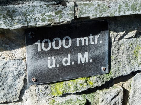 Close-up view of a sign at a fountain in Bavaria that says it is at an altitude of 1000 meters above sea level.