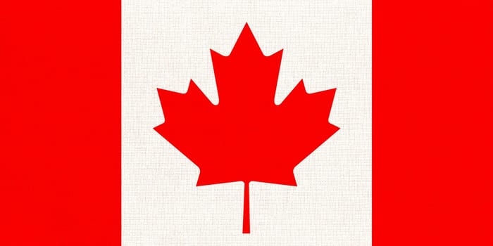 Flag of Canada. Canadian flag on fabric surface with red maple leaf on white background. Canadian national flag on textured background. Fabric Texture. American country