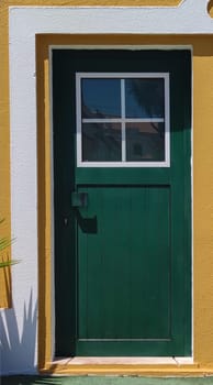 Tiny door painted with vivid colors at Vila Nova de Milfontes house. Little picturesque town on the Alentejo coast, Portugal