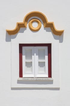 Tiny window painted with vivid colors at Vila Nova de Milfontes house. Little picturesque town on the Alentejo coast, Portugal