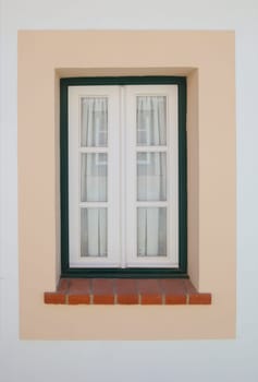 Tiny window painted with vivid colors at Vila Nova de Milfontes house. Little picturesque town on the Alentejo coast, Portugal