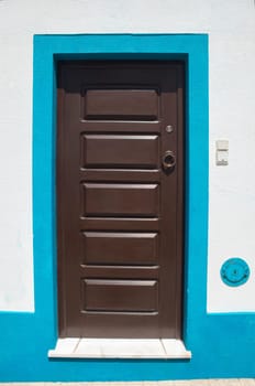 Tiny door painted with vivid colors at Vila Nova de Milfontes house. Little picturesque town on the Alentejo coast, Portugal