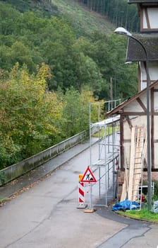 Old house with scaffolding, renovating the home, painting the facade, insulation of the wall