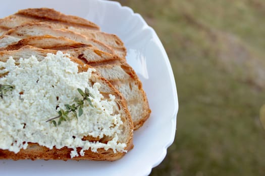 sandwiches from a loaf and with cheese paste on a wooden stand and in a white plate