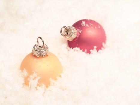 Two old vintage Christmas baubles in snow, vintage style, flat colors, seasonal table top with colorful Christmas balls