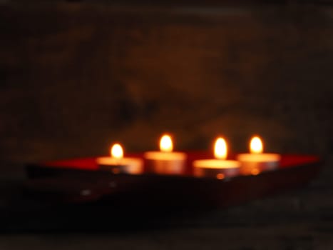 Blurry background of four Advent candles in a dark room, seasonal blurred background