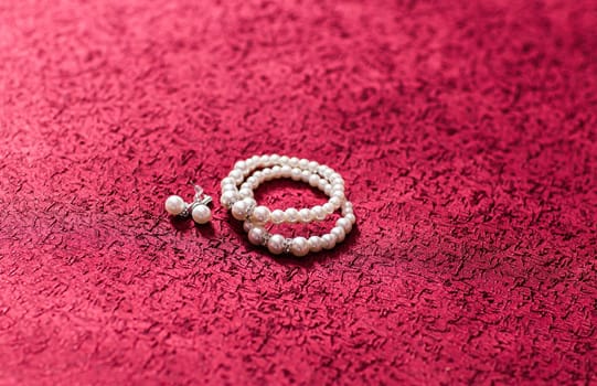 Pearl Earring and bracelet on red background