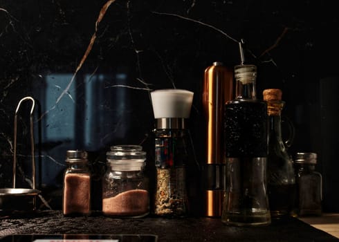in the kitchen there are bottles with seasonings and cooking oil
