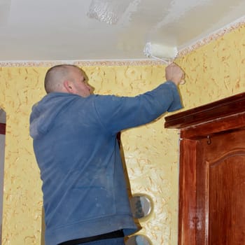 the man works in the room doing repair work