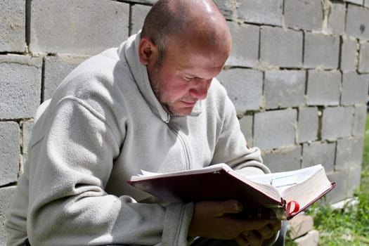 man reading a book in the park