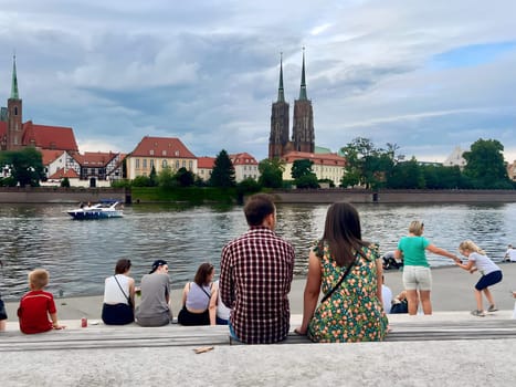 Poland, Wroclaw, July 23, summer 2024. People rest and admire the beautiful view of the Polish city of Wroclaw, fairy-tale houses and the river
