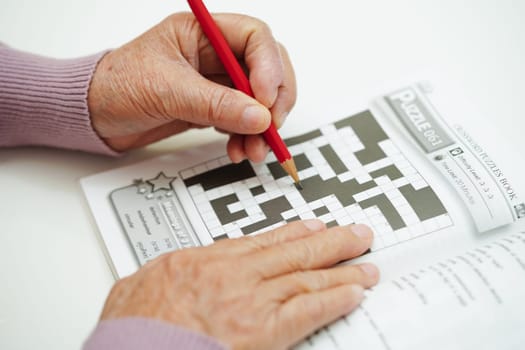 Bangkok, Thailand - May 15, 2022 elderly woman playing sudoku puzzle game for treatment dementia prevention and Alzheimer disease.