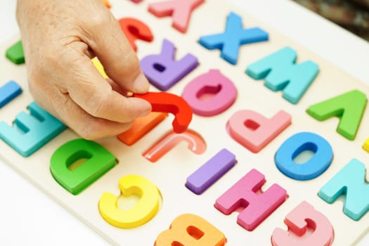 Asian elderly woman playing puzzles game for treatment dementia prevention and Alzheimer disease.