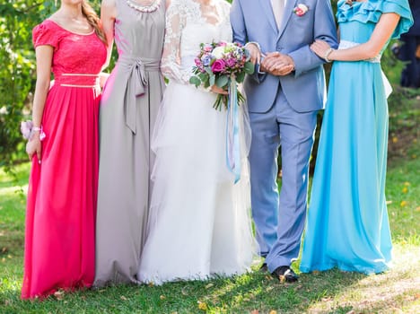 Bride with bridesmaids on the park on the wedding day