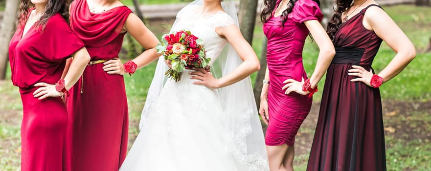 Bride with bridesmaids on the park on the wedding day