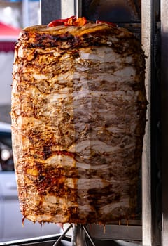 Traditional doner kebab roasted on vertical rotisserie in Turkish street restaurant