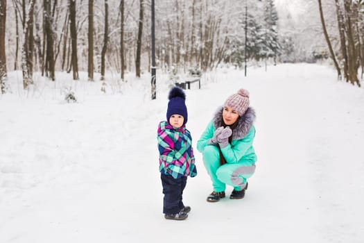 Portrait of happy mother and baby in winter park