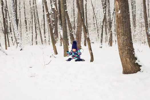 Happy little kid is playing in snow, good winter weather.