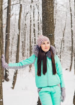 Beautiful winter portrait of young woman in the winter snowy scenery