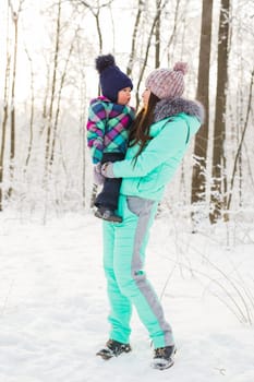 Portrait of happy mother and baby in winter park