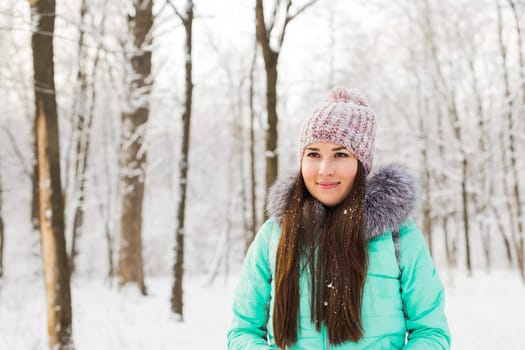 Beautiful winter portrait of young woman in the winter snowy scenery