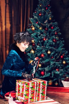 Happy young woman opening christmas present box