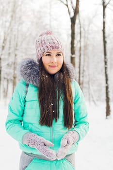 Beautiful winter portrait of young woman in the winter snowy scenery