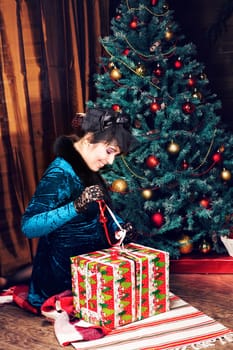 Happy young woman opening christmas present box