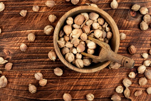White dried cardamom in a wooden mortar, spice.