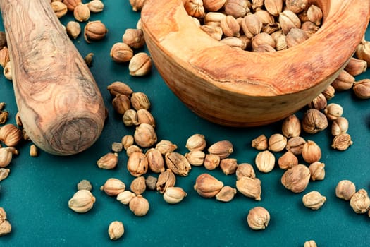 Fragrant white cardamom, kapulaga seed in a wooden bowl, spice.