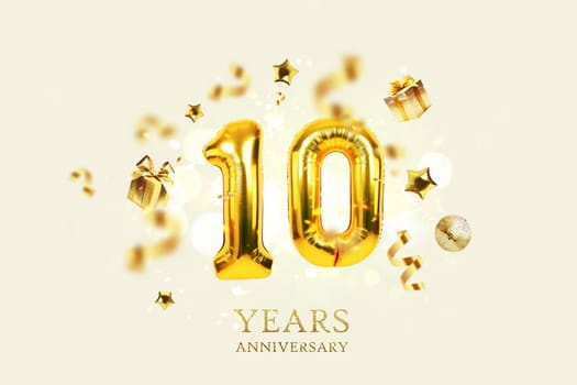 Gold festive balloons 10 years anniversary with golden confetti, presents, mirror ball and stars fly on a beige background with bokeh lights and sparks. Birthday luxury ten card, a creative idea