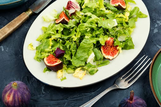 Colorful dietetic salad of greens, ripe figs and diet cheese