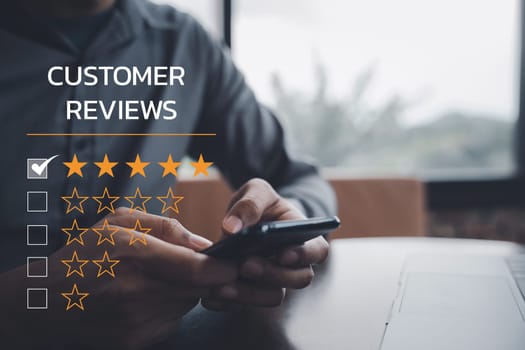 Digital technology is changing business operations. A man's hand using a laptop and smartphone with a 5-star rating icon for customer service satisfaction and online survey