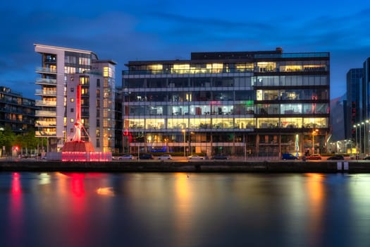 Dublin, Ireland, 10 Oct 2020 Iconic Diving Bell, modern offices and apartment buildings on Sir John Rogerson Quay and blurred Liffey River at dusk