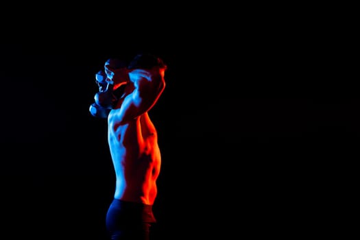 Handsome young fitness sporty strong guy bare-chested muscular sportsman on a studio background