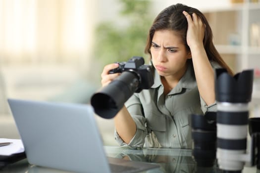 Worried photographer checking result on mirrorless camera at home