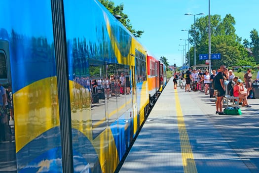 passenger train coming to the railway station. Modern intercity train at the station. Passengers at the railway station. Passengers wait for train on platform. railway transport