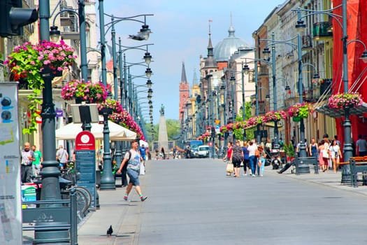 Street in Lodz city. Cityscape. Urban panorama. People walking along city street. People walking along city street. Central street of Lodz Piotrkowska