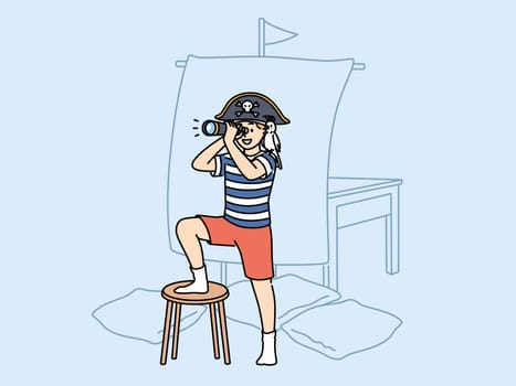 Little boy plays pirate holding spyglass and standing near ship mast made of sheet and imagining long sea voyage. Child pirate with parrot on shoulder performs enthusiastically in children theatre