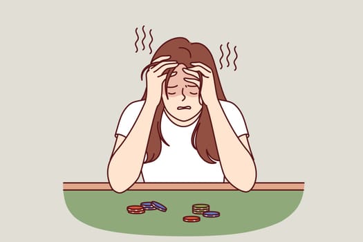 Broke woman sits at poker table with playing chips and cries after losing large money. Sad girl suffers from gambling addiction and lack of strength to give up gambling, leading to bankruptcy
