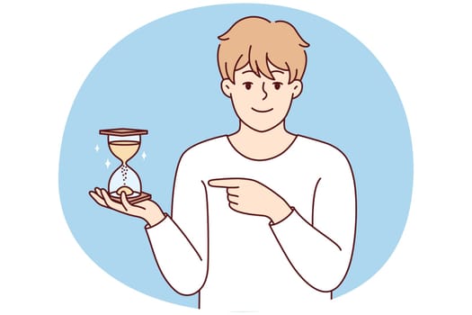 Smiling man point at sandglass
