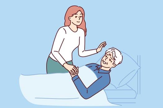 Daughter visits old bedridden father and takes care of gray-haired man in hospital after operation. Caring girl supports elderly hospital patient, sick and myocardial infarction survivor
