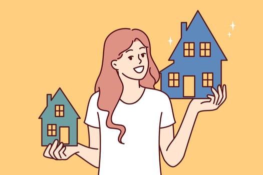 Woman realtor holds two houses offering to choose property she likes and arrange mortgage or rent. Happy girl chooses house or apartment for mortgage in bank and looks at screen smiling