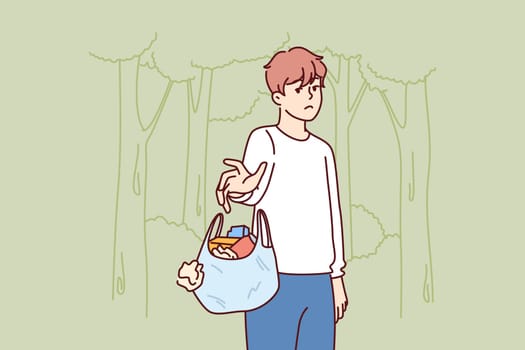 Man throws out bag of garbage in wrong place, polluting nature and showing lack of consciousness. Bad guy polluting ecology with plastic waste and littering with unrecyclable rubbish forest or park