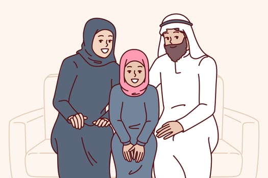 Arab family sits on sofa together with daughter, dressed in islamic clothing hijab or kandura. Arab people smiling posing on couch and inviting to visit Saudi Arabia or Qatar with tourist trip